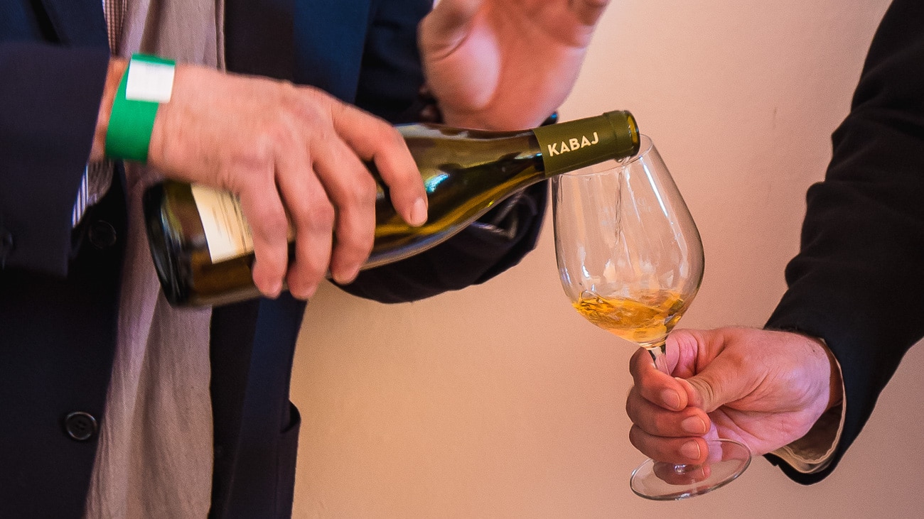 orange wine being poured into a glass